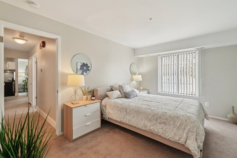 A bedroom with a bed, nightstand, and lamp.