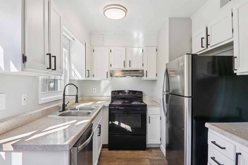 A modern kitchen with a black stove top oven and a black refrigerator.