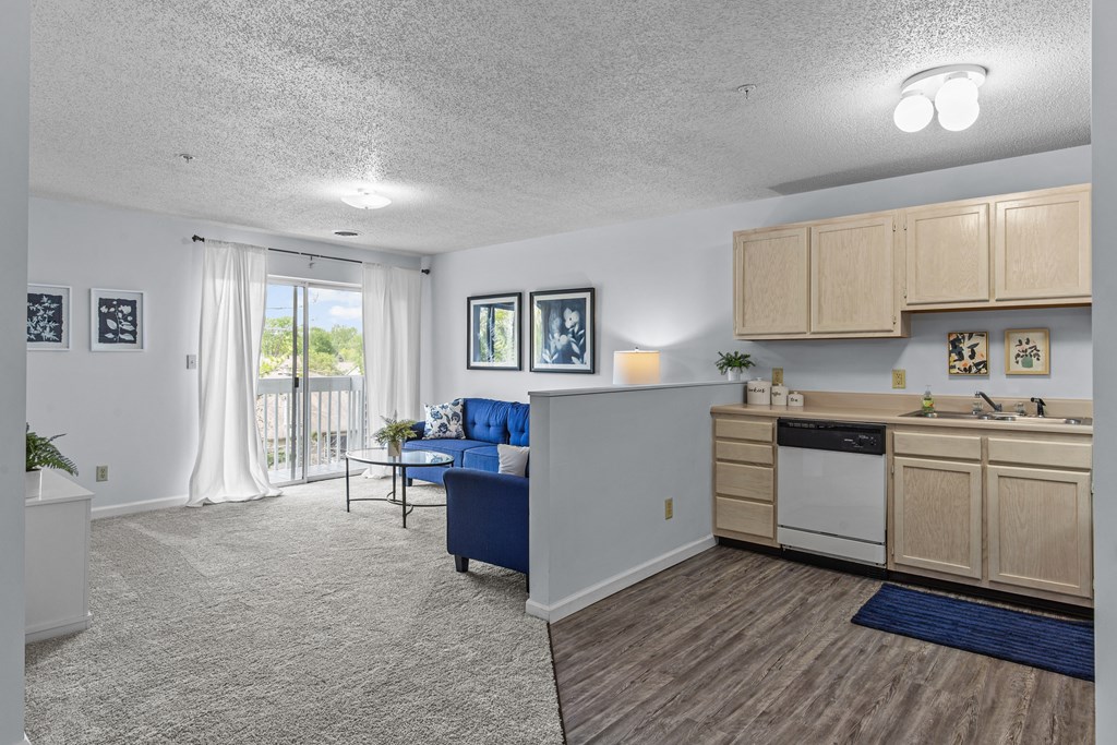 a living room with a kitchen and a sliding glass door