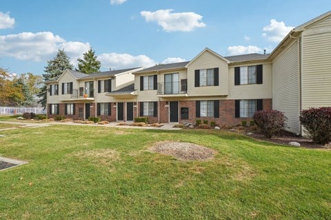 A row of houses with a grassy area in front.
