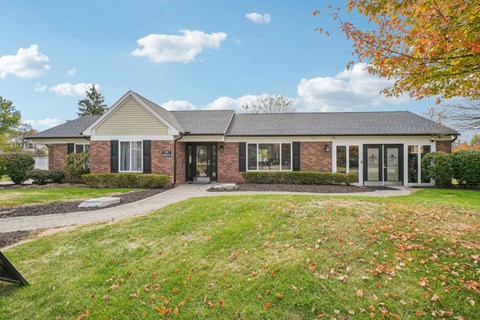 A house with a lawn and trees in the background.