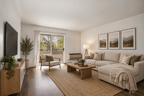 A living room with a couch, chair, and a table with a plant on it.