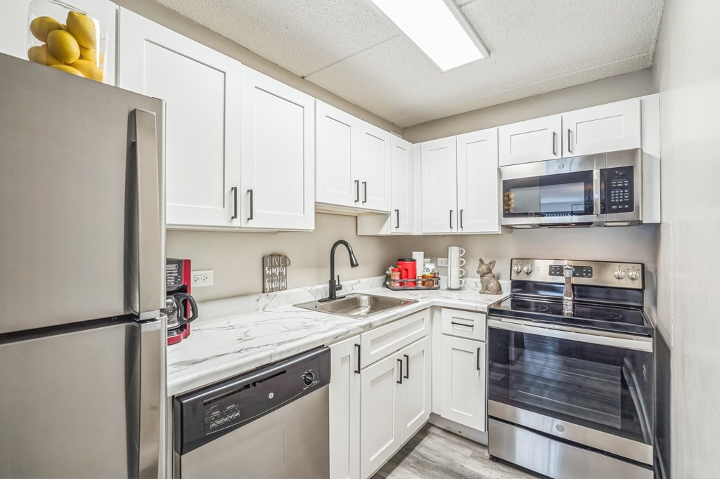 A kitchen with white cabinets and stainless steel appliances.