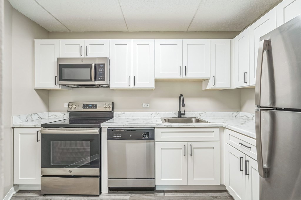 A modern kitchen with stainless steel appliances and white cabinets.