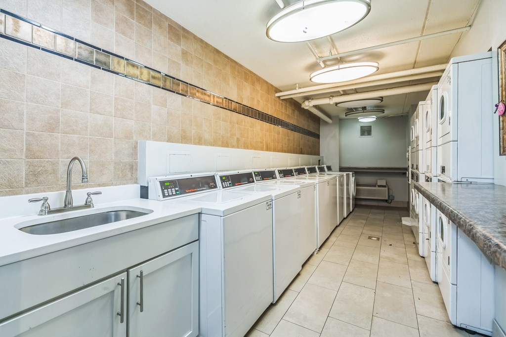 A clean, well-equipped commercial kitchen with white appliances and a tiled floor.