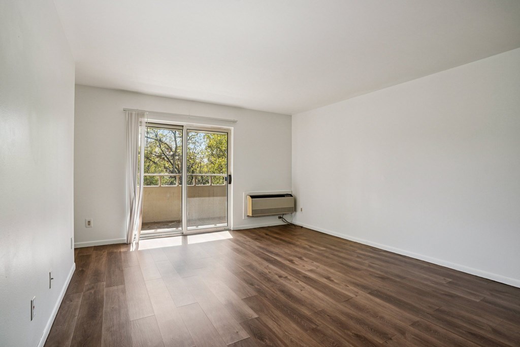 A room with a sliding glass door leading to a balcony.