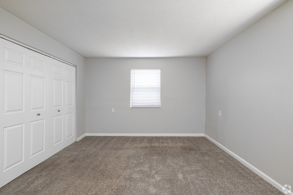 an empty room with carpet and white doors