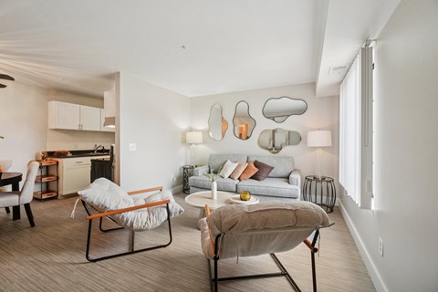 A modern living room with a grey sofa, a chair and a table.