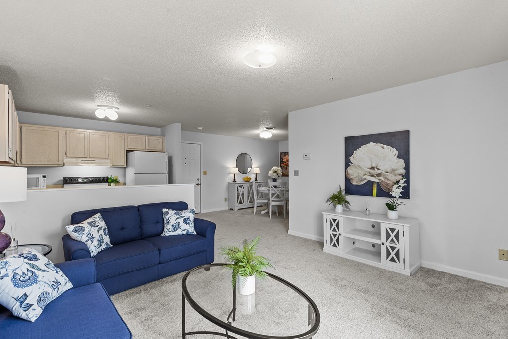 a living room with a blue couch and a glass table