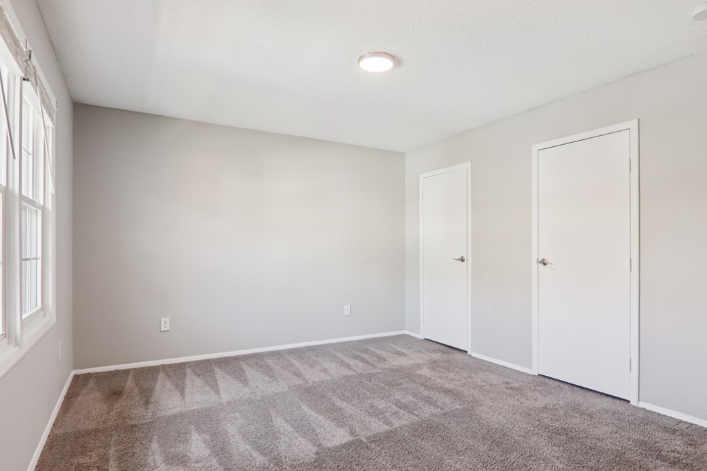 A room with a carpeted floor and white walls.