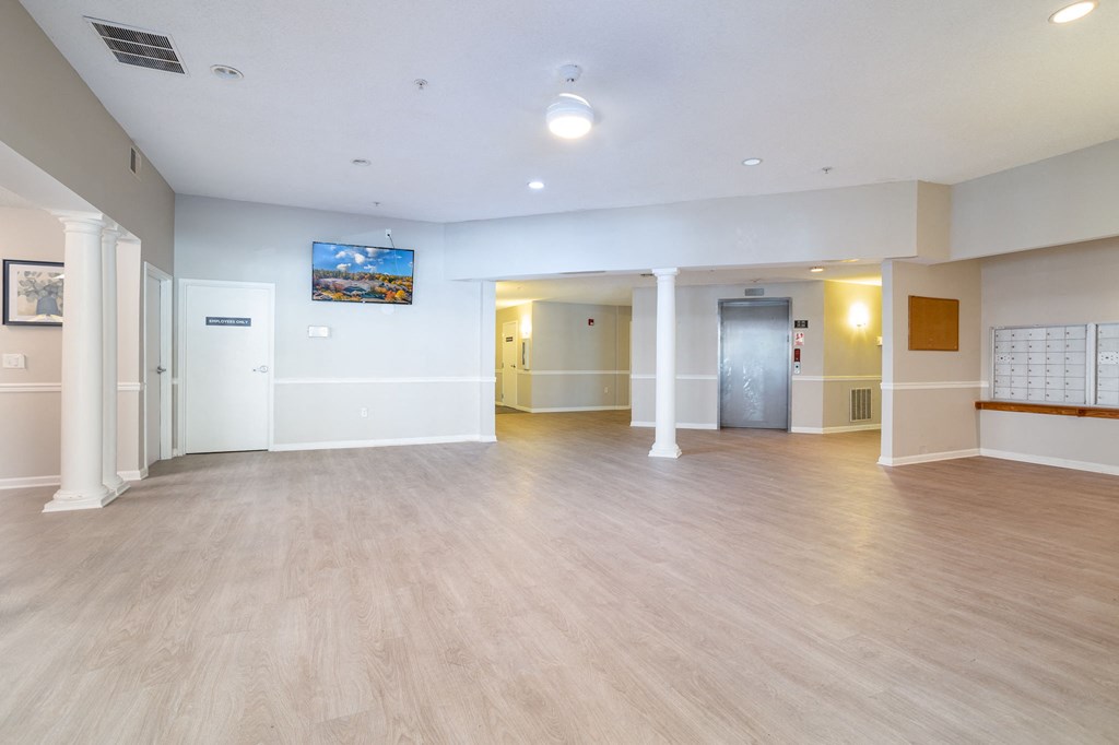 a large room with hardwood floors and a tv on the wall
