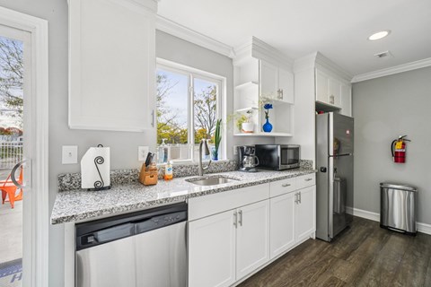 A kitchen with white cabinets and a granite countertop.