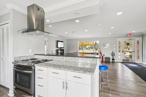 A modern kitchen with a granite countertop and stainless steel appliances.