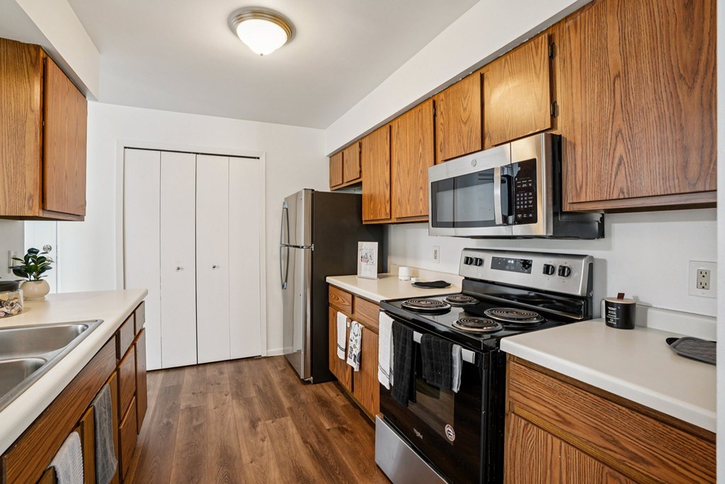 A kitchen with a black stove top oven and a black microwave above it.