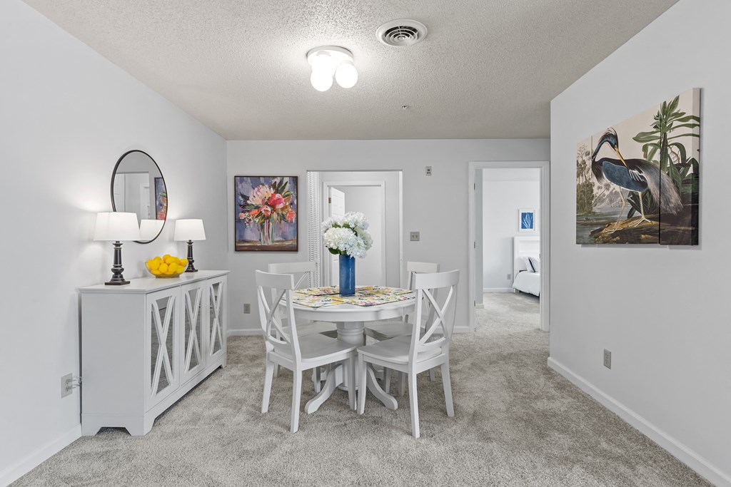 a dining room with a table and chairs and a mirror in a house