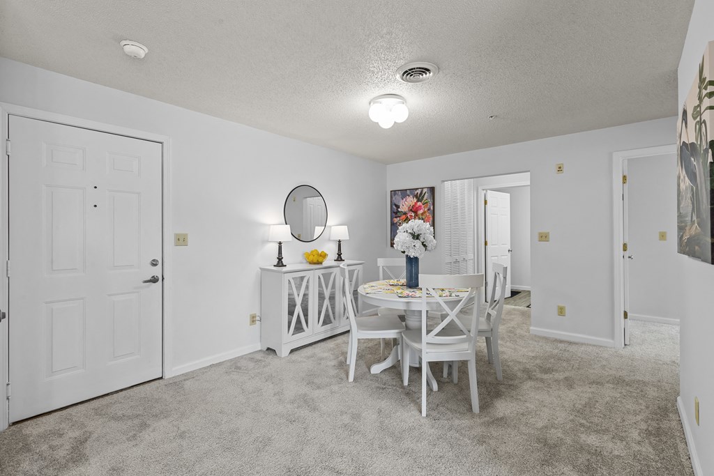 a dining room with a white table and chairs and a white door