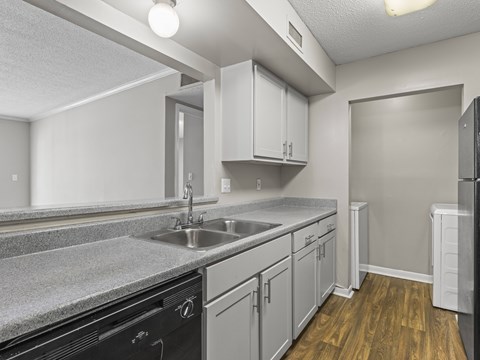 A kitchen with a black oven and wooden floors.