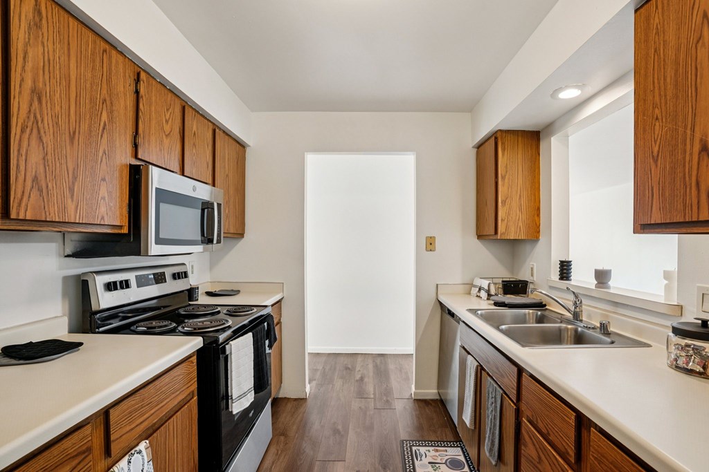 A kitchen with wooden cabinets and a black stove top oven.