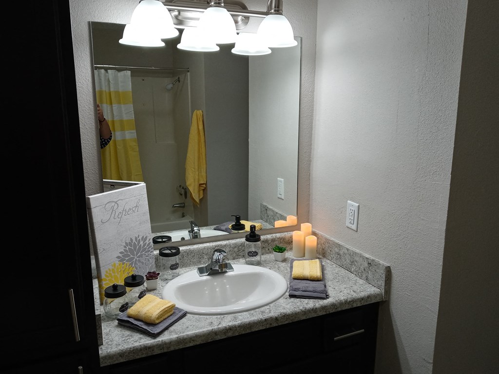 a bathroom with a sink and a mirror and candles