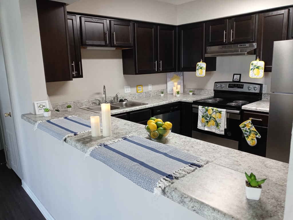 a kitchen with black cabinets and a granite counter top