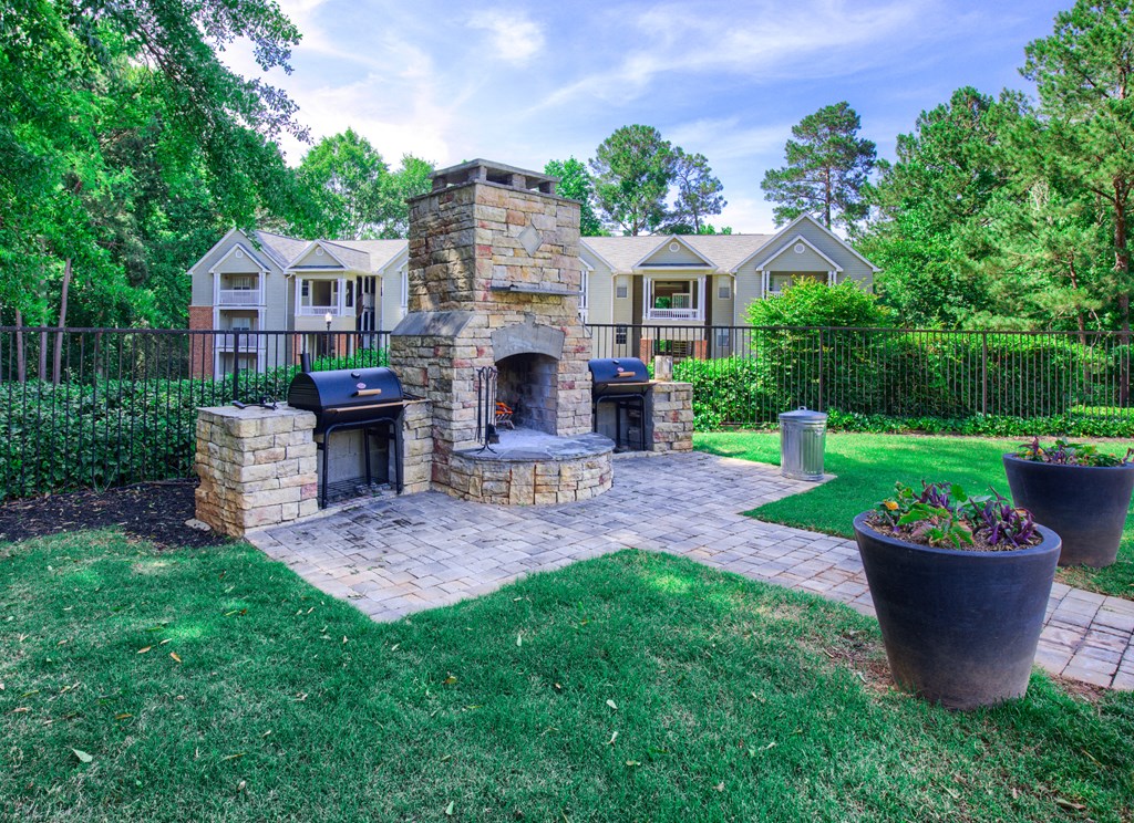 a backyard with a stone fireplace and a patio