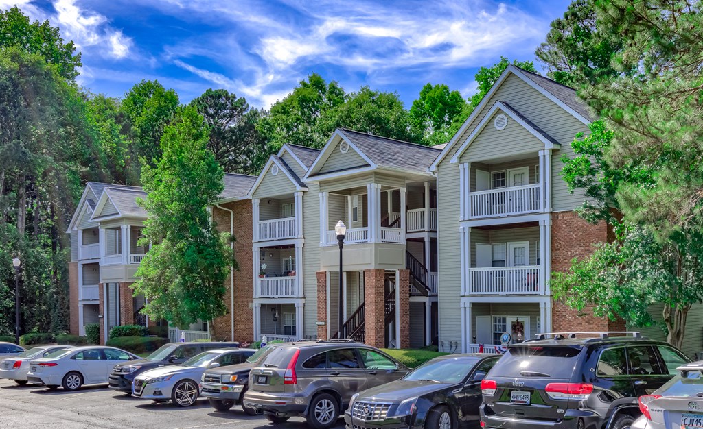 an apartment building with cars parked in front of it