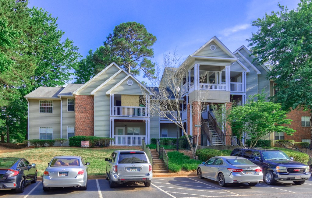 an apartment building with cars parked in a parking lot