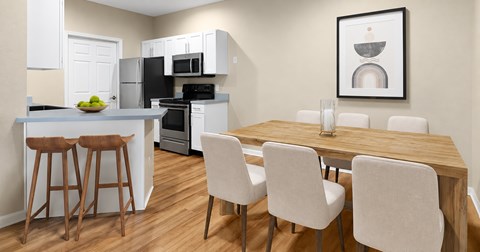A kitchen with a dining table and chairs.
