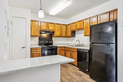 A kitchen with wooden cabinets and black appliances.