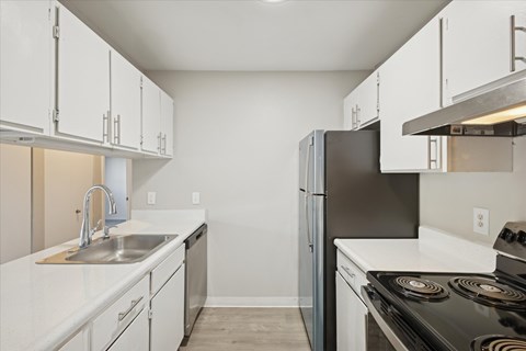 A kitchen with white cabinets and a black stove top oven.