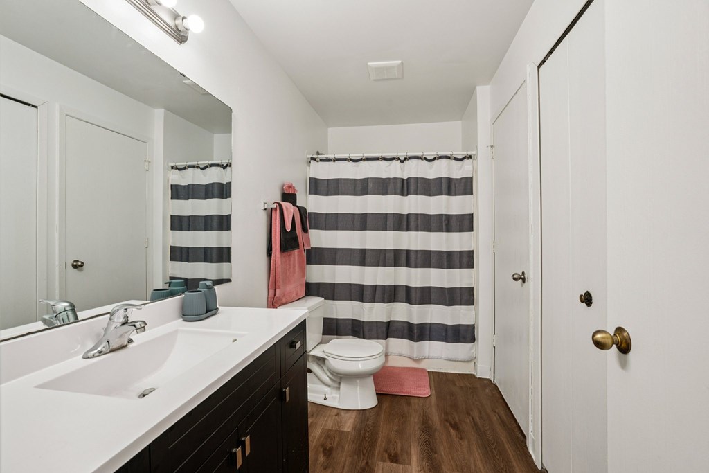 A bathroom with a white sink and a striped shower curtain.