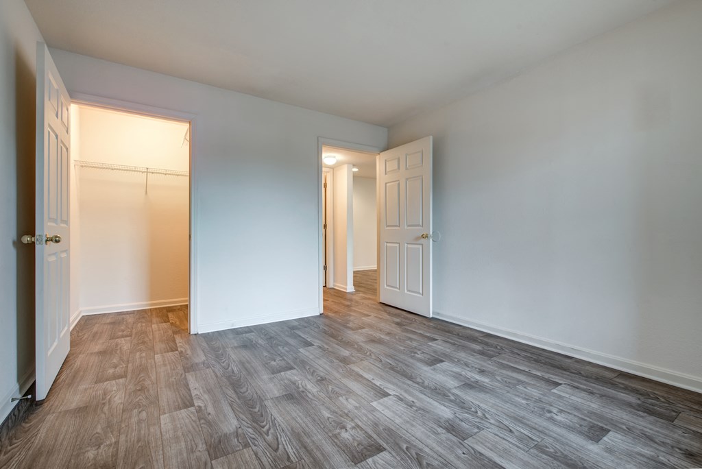 an empty living room with white walls and wood flooring