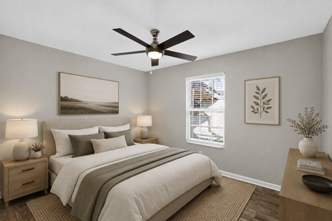 A bedroom with a bed, nightstands, and a ceiling fan.