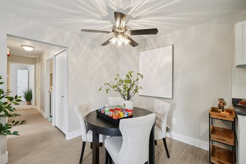 A dining room with a table set for four.