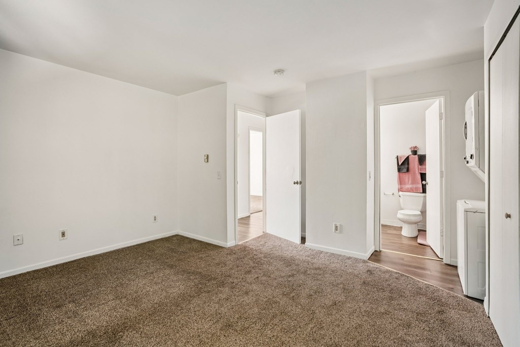 A room with white walls and a brown carpet.