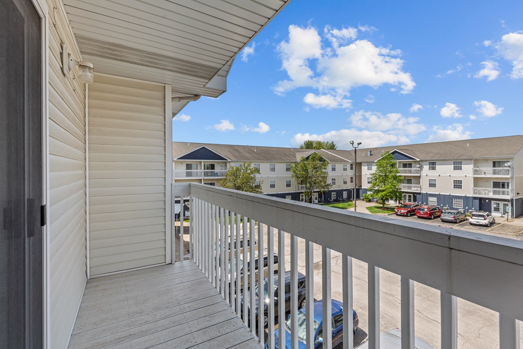 the view from the balcony of an apartment building with a parking lot
