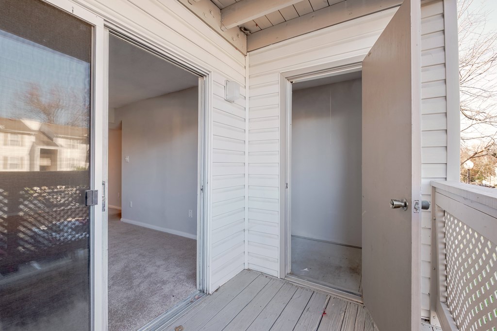 A white house with a deck and a glass door.