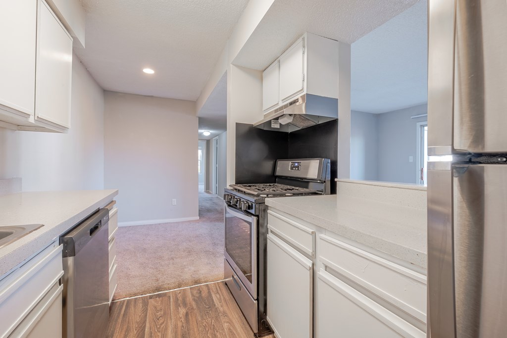 A kitchen with white cabinets and stainless steel appliances.
