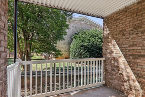 A white fence leads to a green lawn.