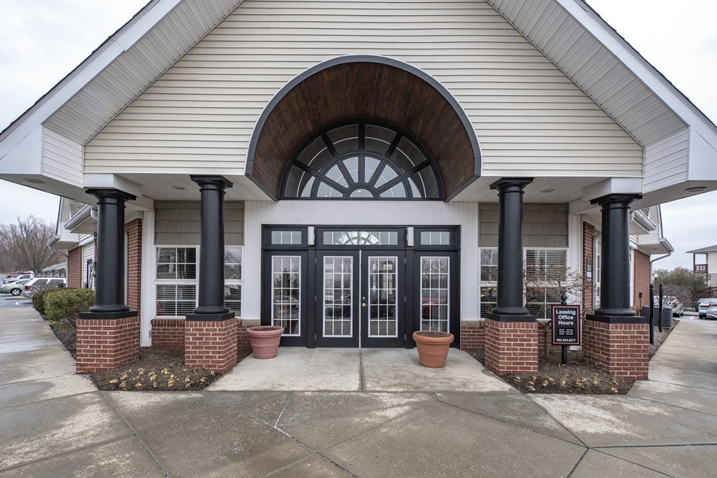 the front of a building with black doors and an arch