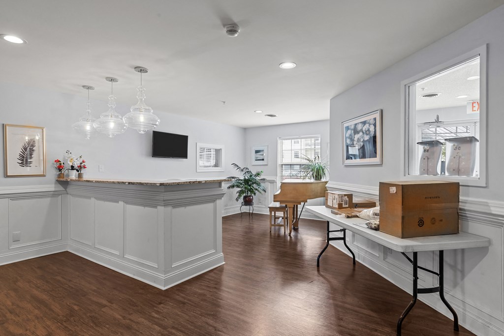 a living room with a desk and a window