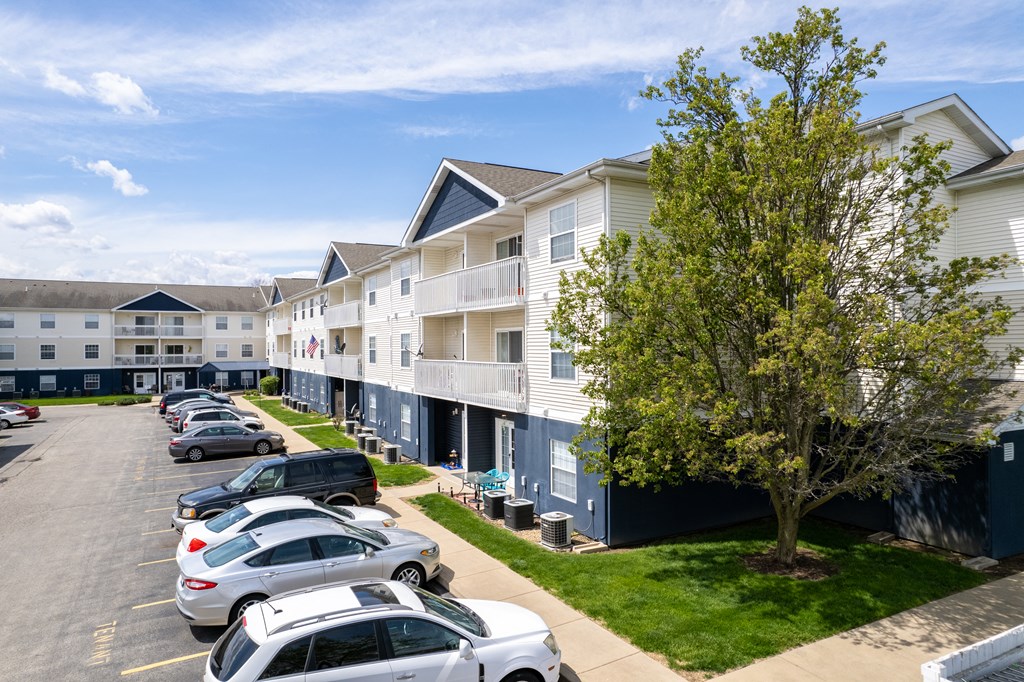 a row of apartment buildings with cars parked in front of them