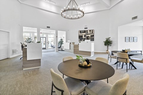 A modern living room with a round table and chairs.