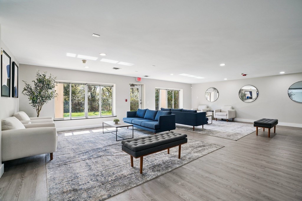A spacious living room with a blue sofa and a white couch.