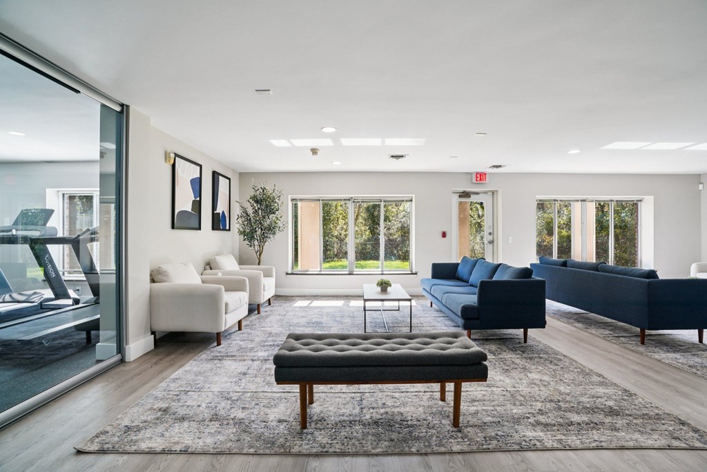 A modern living room with a large window and a view of trees outside.