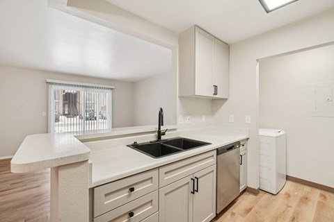 A kitchen with a white counter top and a window.