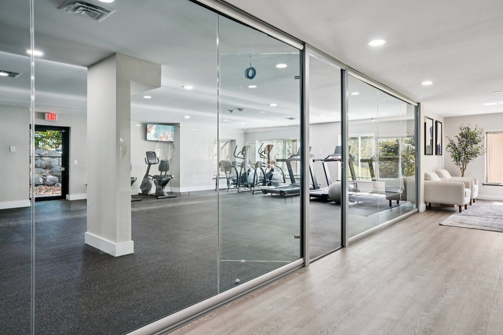 A spacious office with glass walls and a view of the outdoors.