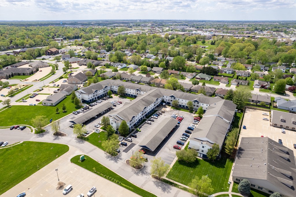 an aerial view of a parking lot in a suburban area with houses and cars