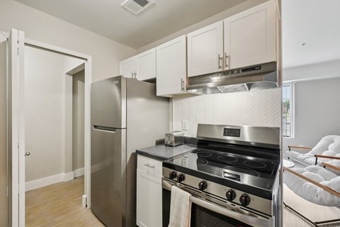 A modern kitchen with a stainless steel refrigerator, dishwasher, and oven.