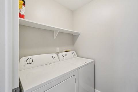 A white washing machine in a small laundry room.